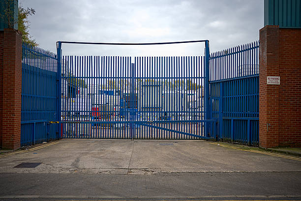 istock Closed industrial gate with blue metal bars. 2242614973