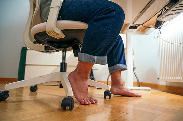istock Barefoot man sitting on ergonomic office chair. 2242617115