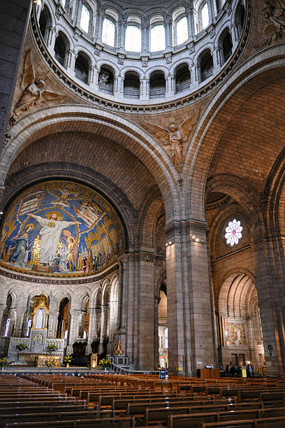 Paris France June 2 2025 Vertical view of Sacre Coeur Basilica interior showing architectural symmetry high vaulted ceiling and decorative elements.