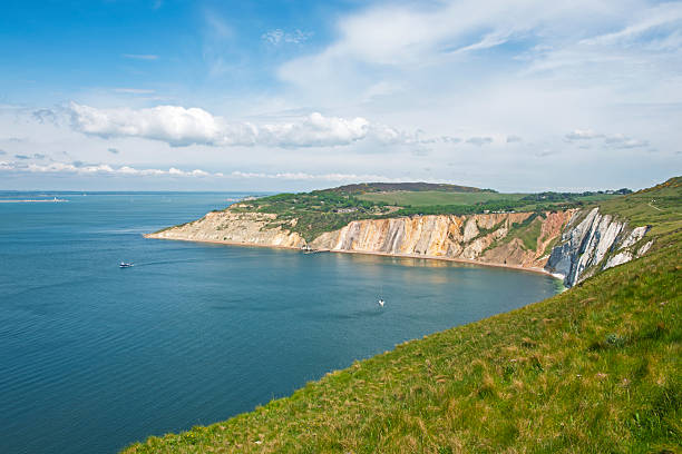 Panoramic scenic landscape view of stunning beautiful coastal shoreline scenery with steep cliffs in a bay looking out to sea ocean