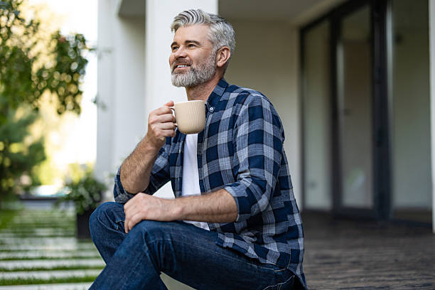 istock Contented senior bearded man with a cup of coffee in hands 2242623797