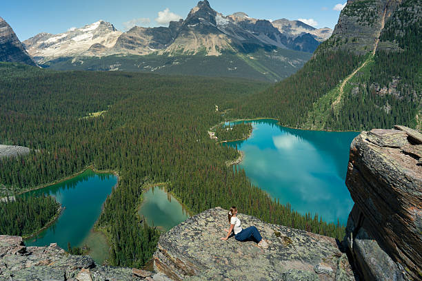 istock Woman enjoying a serene moment on a rock ledge overlooking pristine waters. 2242624425