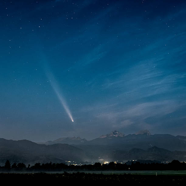 istock Comet NEOWISE streaks across the starry night sky over mountains. 2242629951