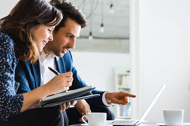 istock Colleagues discussing over laptop in office 2242630412