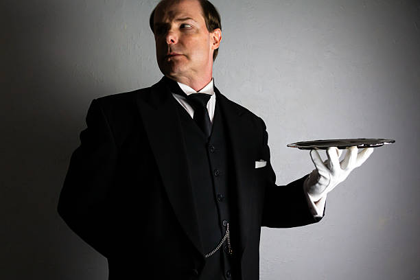 istock Polite Butler Holding Serving Tray in Dignified Manner 2242635432