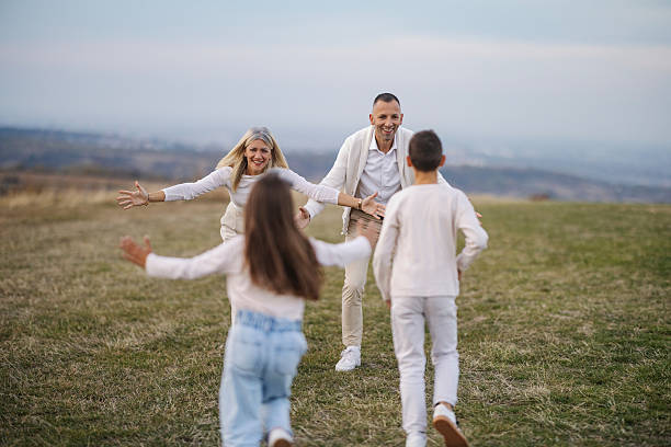 istock Parents happily greeting children on open field reunion 2242635511