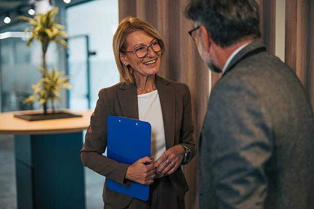 istock Mature businesswoman smiling while having a conversation with colleague 2242637758