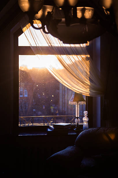 istock Golden Sunlight Streaming Through Window with Dust Particles and Cozy Interior 2242642337