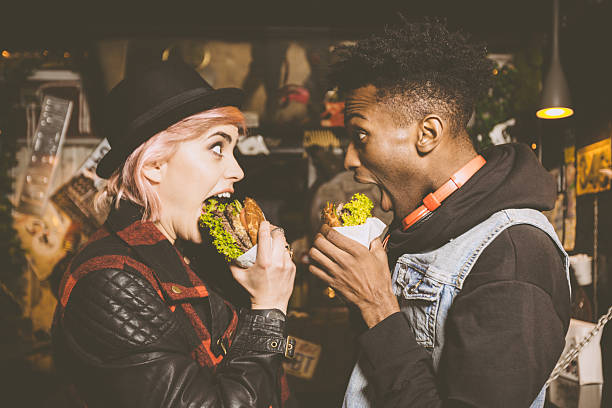 istock Funky couple eating burger in the pub 2242642665
