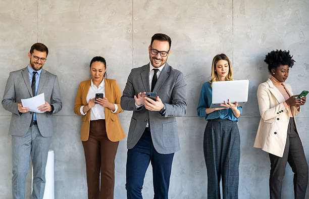 istock Busy smiling executive business team using digital devices in office. Diverse professional people 2242647842