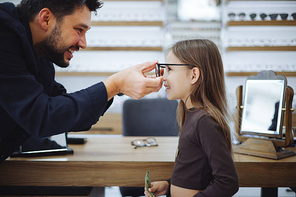 istock Lttle girl choosing new eyewear in optical store 2242649338