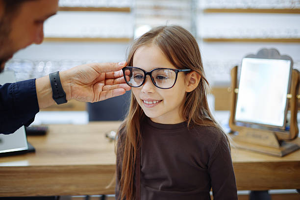 istock Lttle girl choosing new eyewear in optical store 2242649421