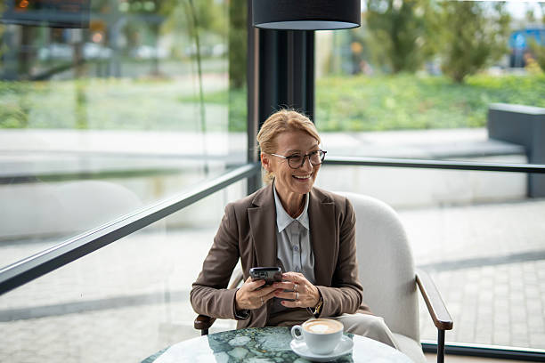 istock Businesswoman checking phone during coffee break at cafe 2242650823