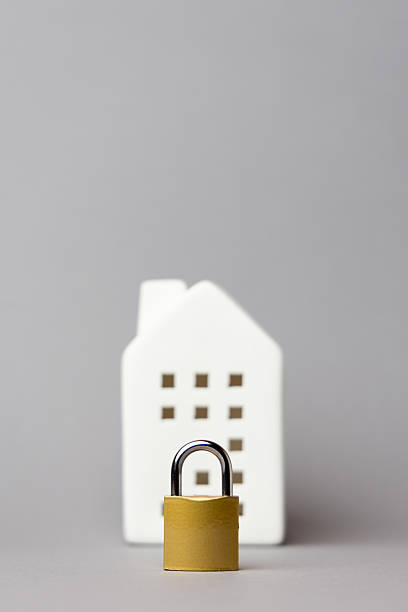 istock White house model with a golden padlock in front, symbolizing investment security and stability in real estate and financial planning. copy space 2242654124