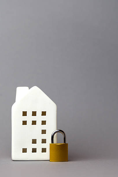 istock White house model with cut-out windows and a yellow padlock, symbolizing security and protection in finance and technology concepts. copy space 2242654129
