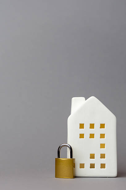 istock White ceramic house model with cut-out windows and a golden padlock, symbolizing security and protection in finance and technology concepts. copy space 2242654146