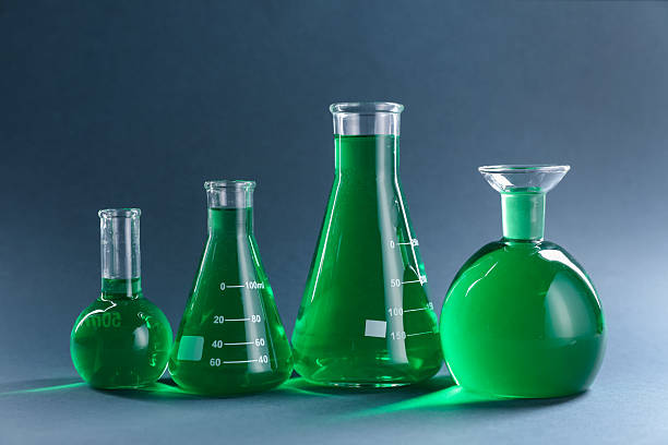 Close up of green liquid in a beaker while heating on a magnetic stirrer in laboratory.
