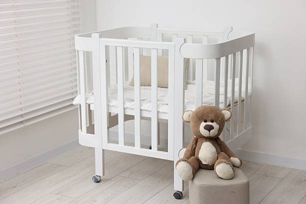 istock Baby's room with crib and cute teddy bear. Interior design 2242655428