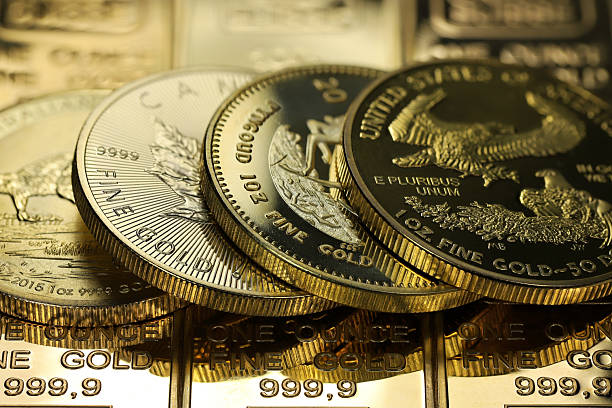 istock 4 different 1 ounce gold bullion coins on a layer of gold ingots 2242655607