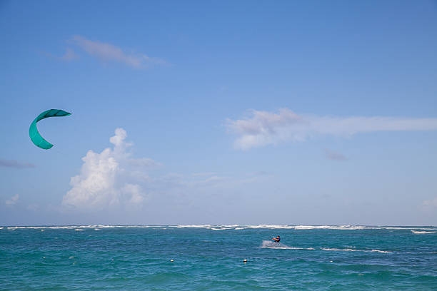 istock A lone kite surfer glides across turquoise waves as a teal kite soars 2242657016