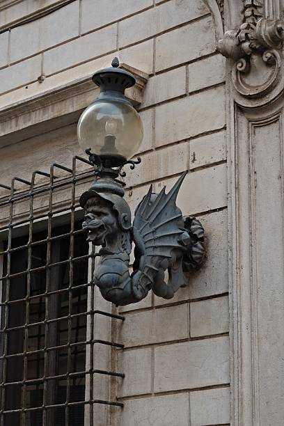 An old, beautiful gargoyle street lantern found in Rome, Italy.