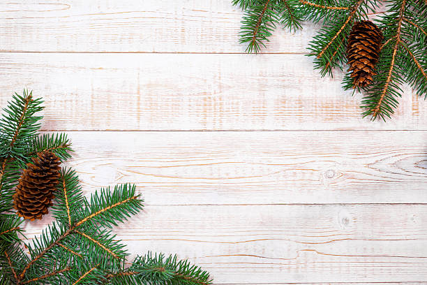 istock Christmas background - fir branches with cones on a white wood t 2242659508