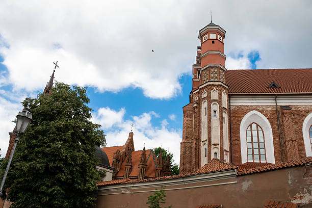 Vilnius, Lithuania - July 01, 2015 - Historic brick church with tower against blue sky and clouds.