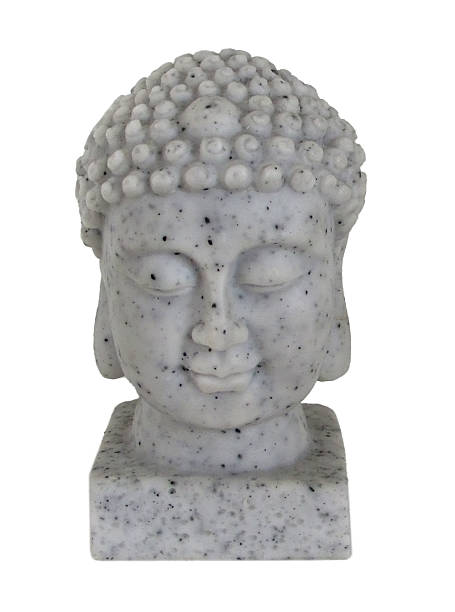A miniature Buddha sculpture on the edge of a pool. Green vegetation in the background