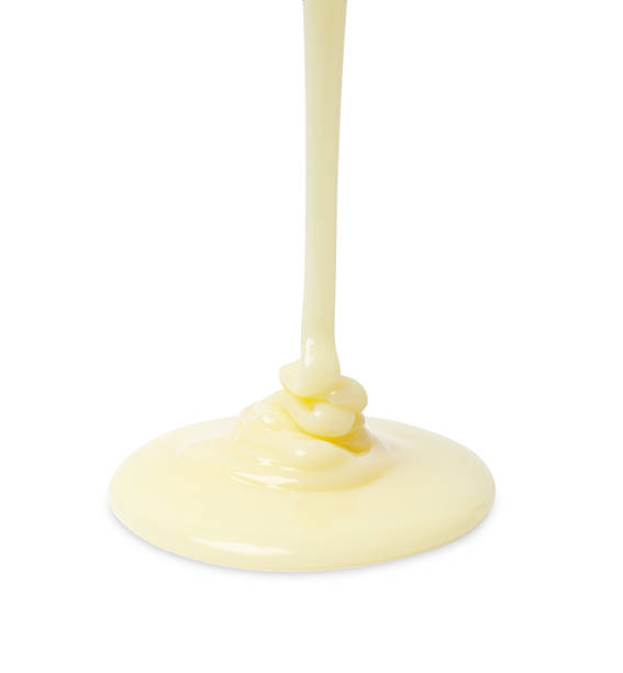 istock Pouring delicious condensed milk isolated on white 2242662872