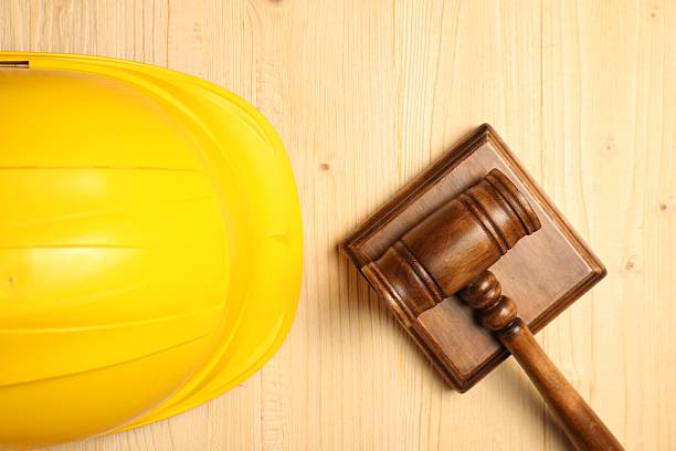 Accident at work concept. Gavel and hardhat on wooden table, top view