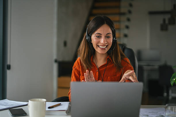 istock Woman with headset teleconferencing from home office, video calling with colleagues 2242663822