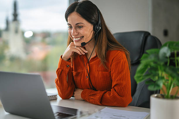 istock Woman working remotely using headset and laptop for video call 2242663823