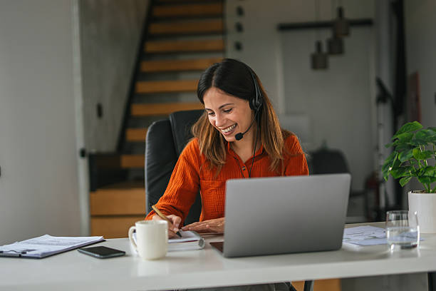 istock Young woman working from home using headset and laptop 2242664068