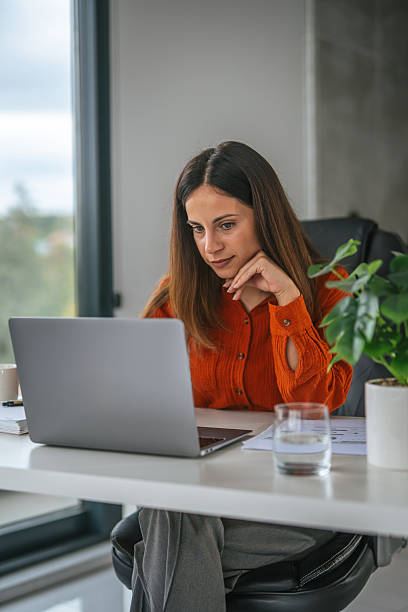 istock Woman working remotely on laptop at home office desk 2242664150