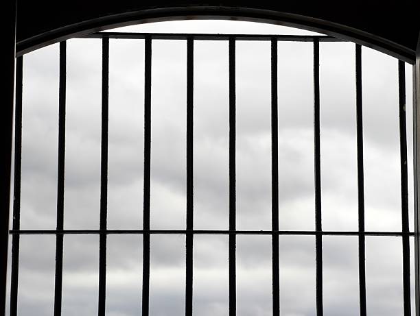 Human hand gripping the steel bars.