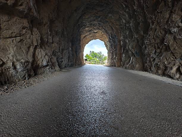 istock scenic tunnel glimpse, paved tunnel with reflective asphalt directs gaze toward distant horizon 2242667856