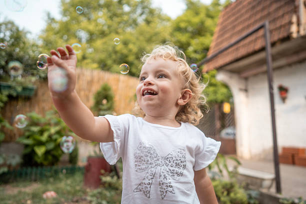 istock Joyful Toddler Reaching for Bubbles Outdoors on a Sunny Summer Day 2242668274