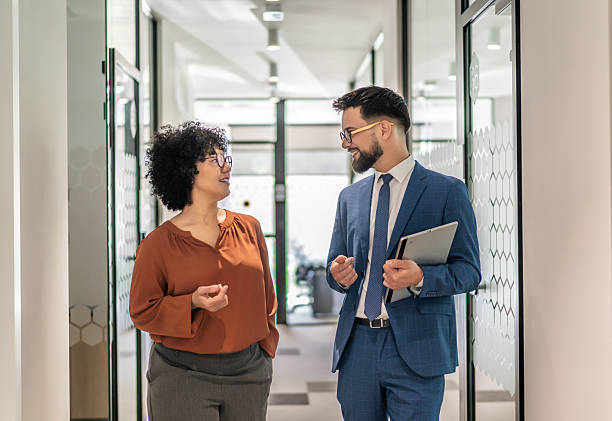 istock Business colleagues walking and discussing in office corridor 2242668459