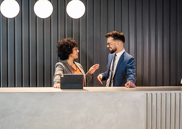 istock Diverse business colleagues having informal conversation at reception desk 2242669443