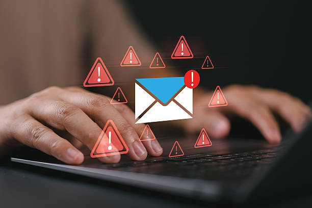 istock A man typing on a laptop with warning email icons, representing email threat, phishing attack, malware, data breach, cybersecurity alert, scam message, spam risk, and online fraud protection. 2242670590