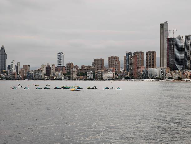 istock rowing team on waterfront exercises, athletes practice rowing along city waterfront with skyline 2242671482