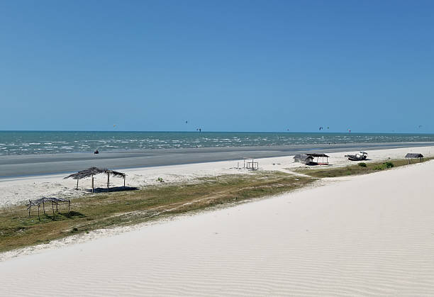 istock Tropical Prea beach with white sand, gentle waves, and several thatched huts along the shore. Clear blue sky and turquoise sea create a serene vacation and nature escape. 2242671985