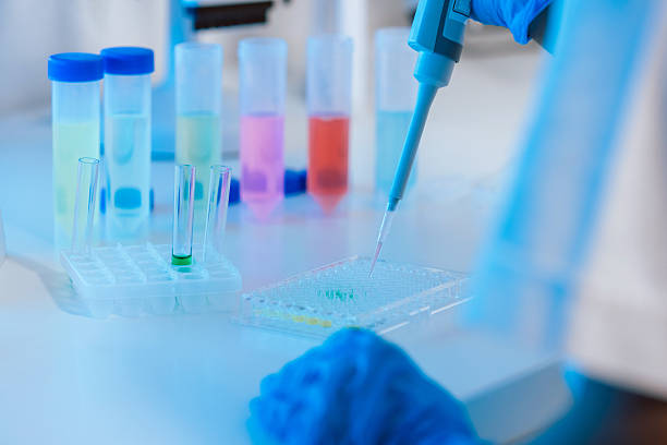 istock Scientist using digital pipette for measuring liquids, dripping fluid to test tubes 2242672755