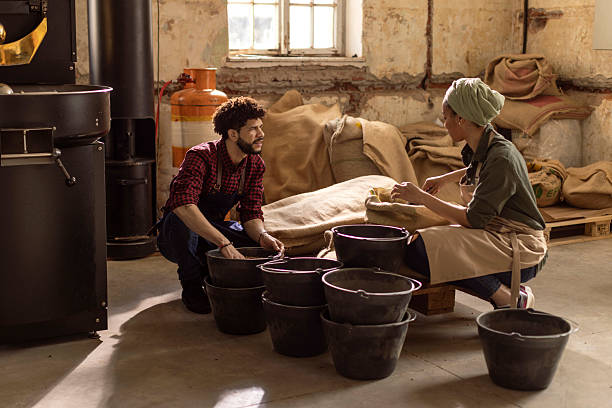 istock Two People Bagging Coffee Beans in a Rustic Industrial Workshop With Roasting Equipment 2242674666