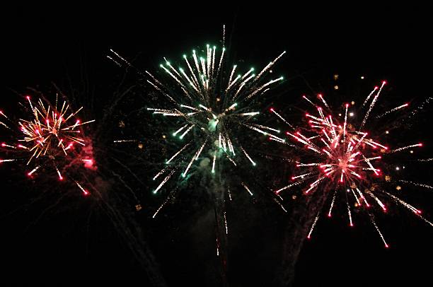 istock Red, green, and golden firework explosions in the night sky. 2242675797