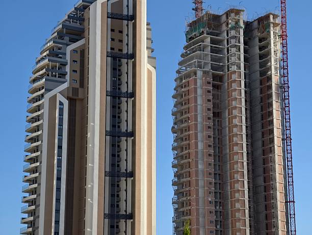 istock construction with towers and sky, building structures showing finished and active construction 2242676535