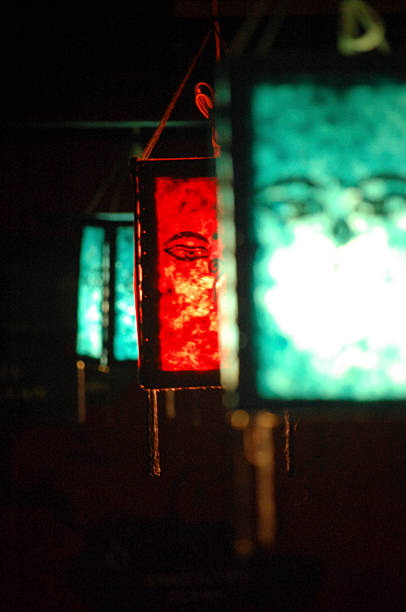 Colorful traditional lanterns with unique patterns are hanging in the dark, creating an artistic and festive atmosphere.