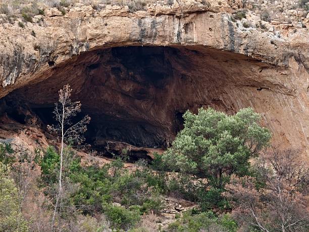 istock secluded cave amid nature, remote rock shelter surrounded by juniper and weathered sandstone 2242680434