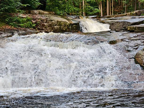 istock powerful waterfall on rocky ledge, majestic waterfall flowing over textured granite into wooded 2242681814