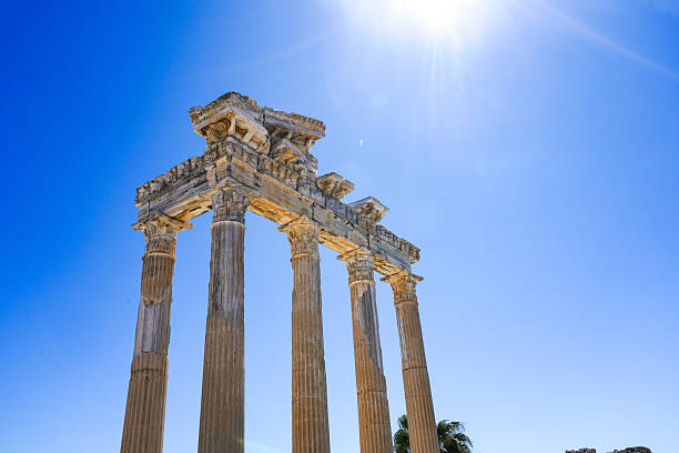Ancient Columnar Structure Beneath a Vibrant Blue Sky with Sunlight Illuminating the Historic Architecture and Captivating Nature Surrounding It. Side Antik.